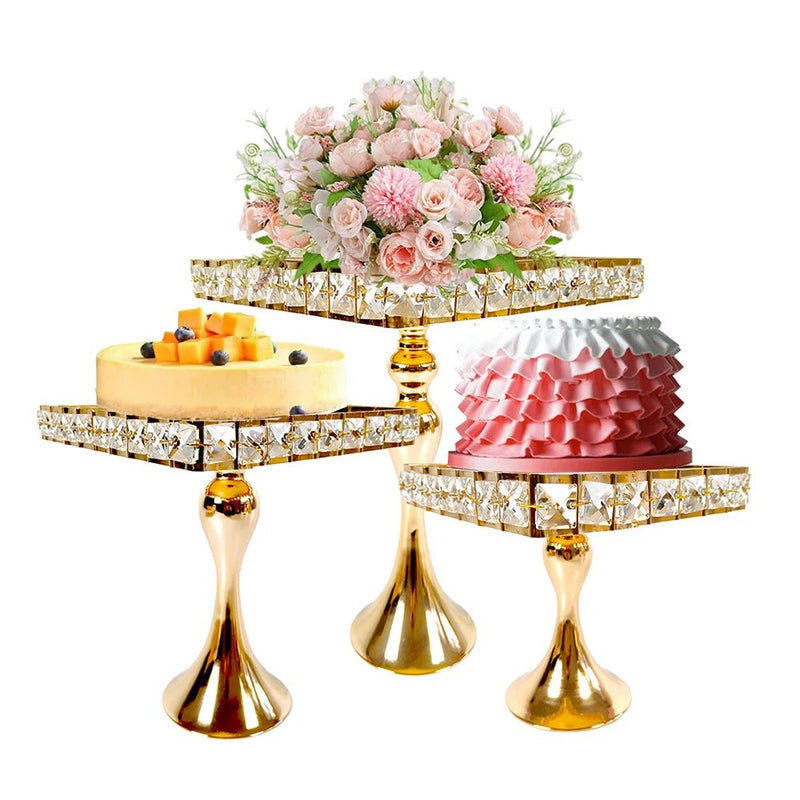 Trois présentoirs à gâteau dorés à plateaux de cristal garnis de gâteaux et d'un bouquet de roses roses