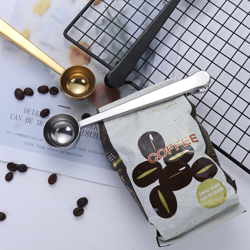 Pince de fermeture et mesure à café en inox posées sur un sachet de café
