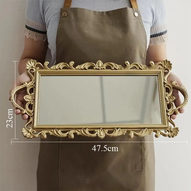 Plateau miroir rectangulaire doré de 47,5 cm de long tenu à deux mains, avec ses dimensions