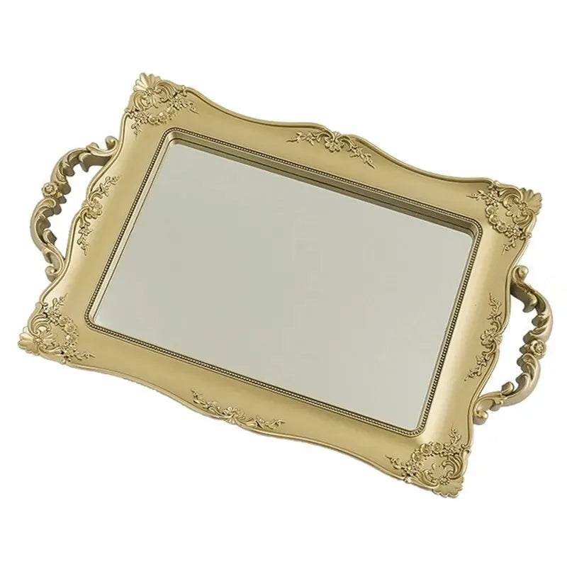 Plateau miroir rectangulaire doré à poignées sculptées, vu en perspective sur fond blanc