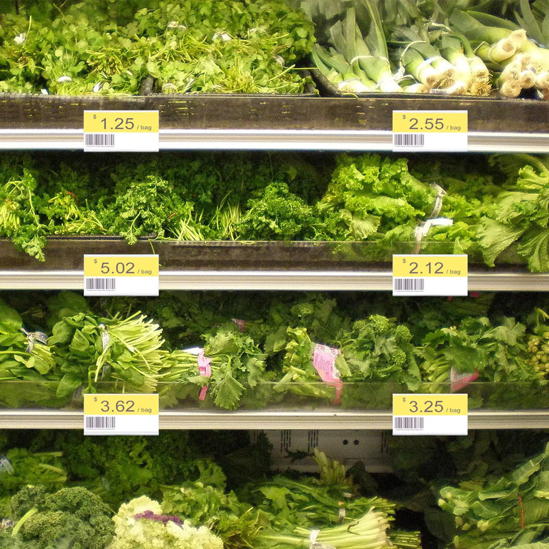 Porte-étiquettes transparents en L fixés au bord de rayons de légumes verts, avec étiquettes jaunes