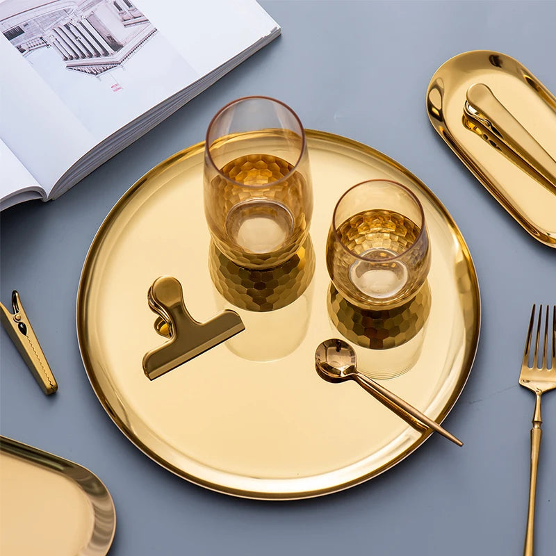 Plateau doré avec deux verres, des pinces dorées et des couverts