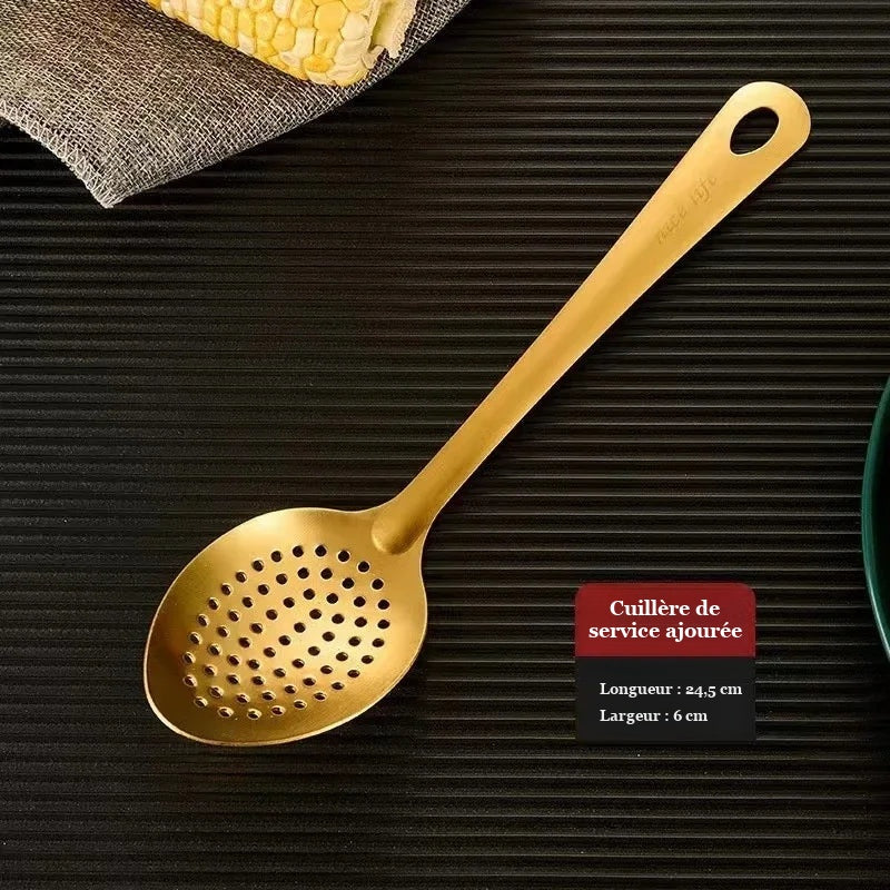 Cuillère de service dorée et perforée de 24,5 cm de long sur fond sombre