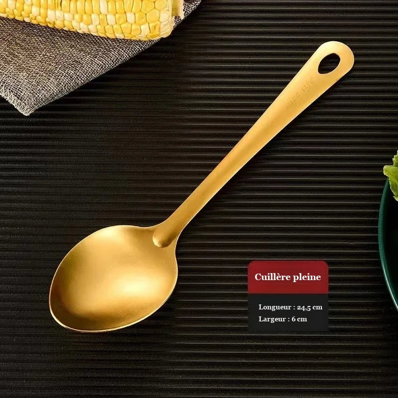Cuillère pleine dorée de 24,5 cm de long sur fond sombre
